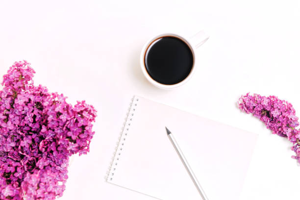 istock Workplace with cup of coffee dairy pencil lilac flowers 820765576