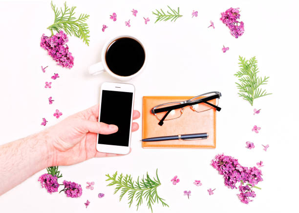 istock Frame lilac flowers man hand mobile phone pen dairy glasses 820765656