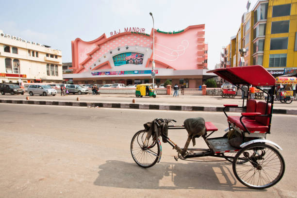 Traditional indian trishaw transport stands past the famous Raj Mandir movie theater Jaipur, India - January 25, 2015: Traditional indian trishaw transport stands past the famous Raj Mandir movie theater on January 25, 2015. Raj Mandir Cinema was designed in Art Moderne style in 1976 showtime stock pictures, royalty-free photos & images