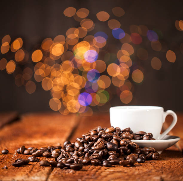 Coffee cup and coffee beans on bokeh background.