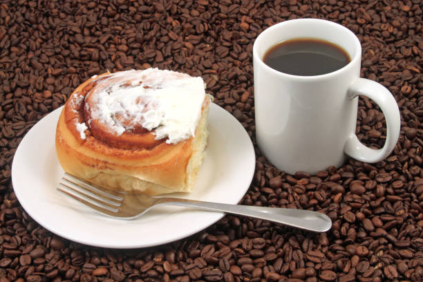 Coffee cup with pastry on a coffee bean background