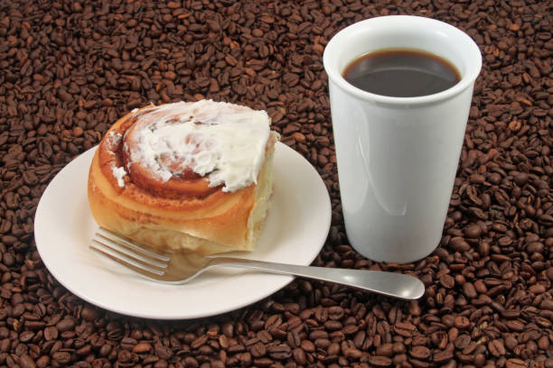 Coffee cup with pastry on a coffee bean background