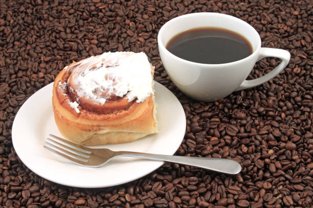 Coffee cup with pastry on a coffee bean background