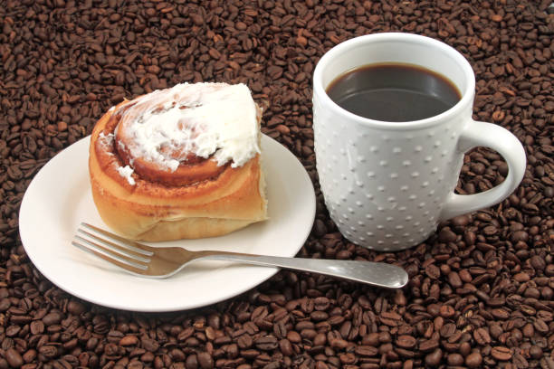 Coffee cup with pastry on a coffee bean background