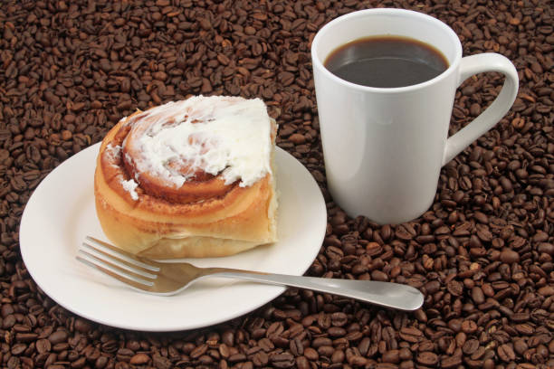 Coffee cup with pastry on a coffee bean background