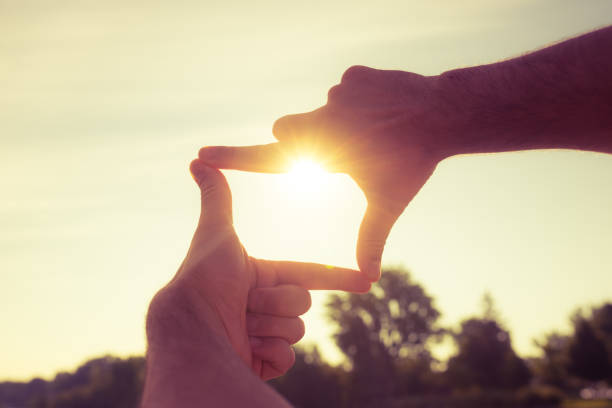 finger frame capturing the sunset - imagination creativity finger frame frame imagens e fotografias de stock