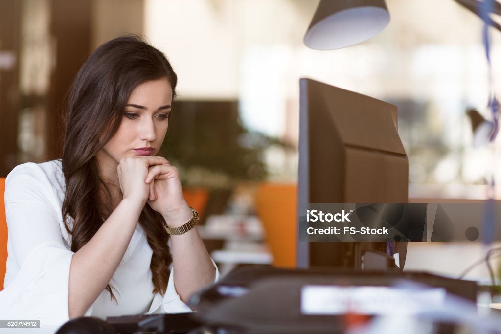 Young tired business woman with headache sitting in workplace Young tired business woman with headache sitting in workplace. Adult Stock Photo