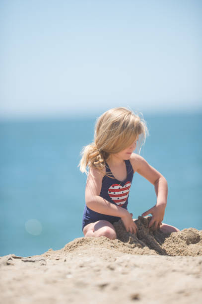 istock Cute young girl digging in the sand 820801610
