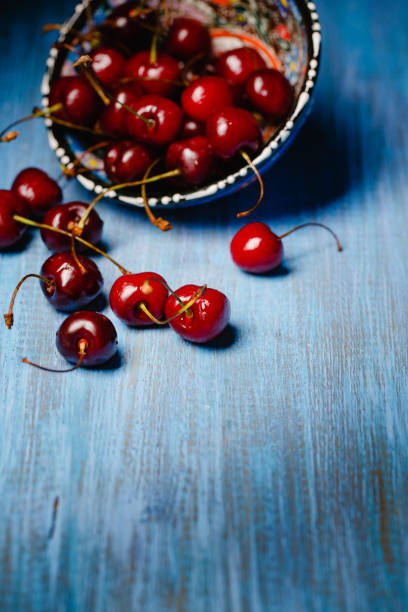 istock Cherries scattered on a wooden countertop 820807086