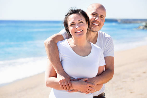 istock Couple gladly hugging each other and enjoying the beach 820808256
