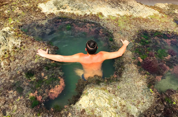 istock Young backpacker male tourist taking a break inside a cave lagoon 820809640