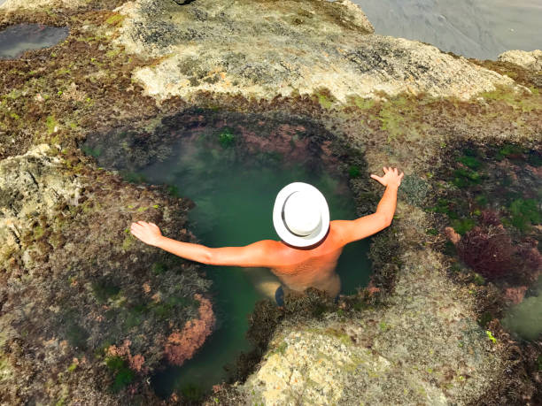 istock Young backpacker male tourist taking a break inside a cave lagoon 820809646