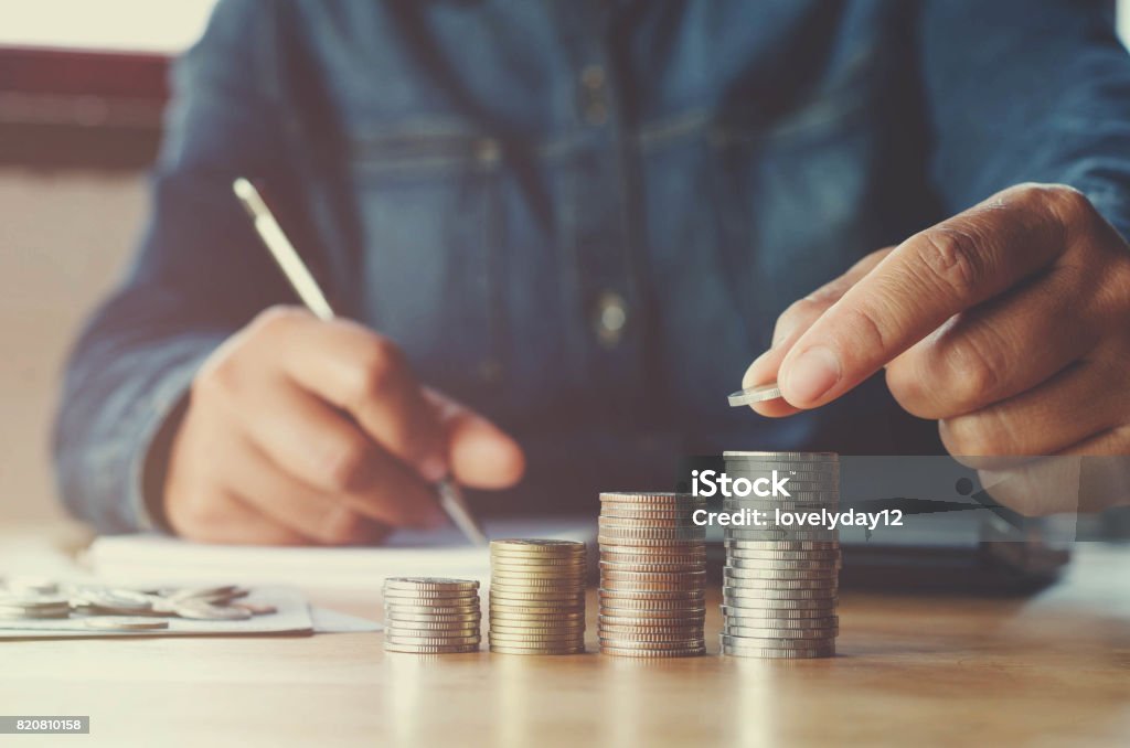 business accounting with saving money with hand putting coins on stack concept financial Savings Stock Photo