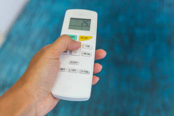 istock Females hands adjusting temperature in air conditioner remote 820812718