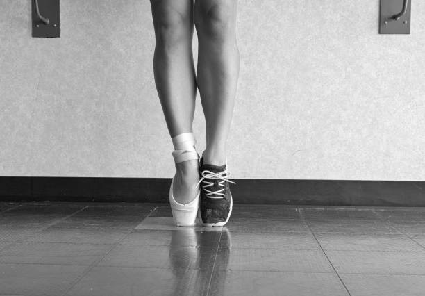 Young beautiful model girl is engaged in ballet in a training bodysuit and Pointe shoes