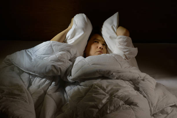 istock Woman with insomnia lying in bed with open eyes 820816434