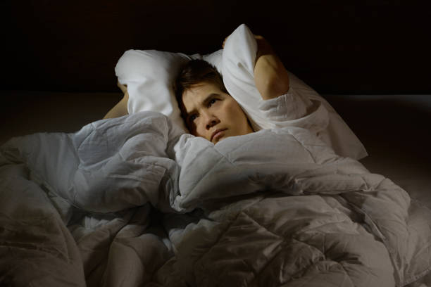 istock Woman with insomnia lying in bed with open eyes 820817128