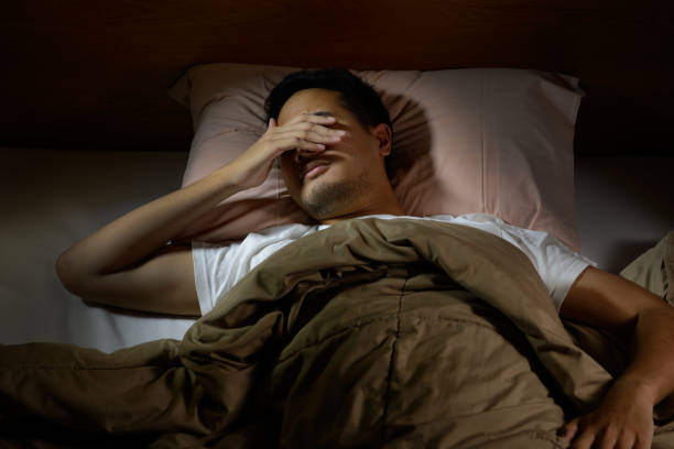 istock Depressed man suffering from insomnia lying in bed 820817706