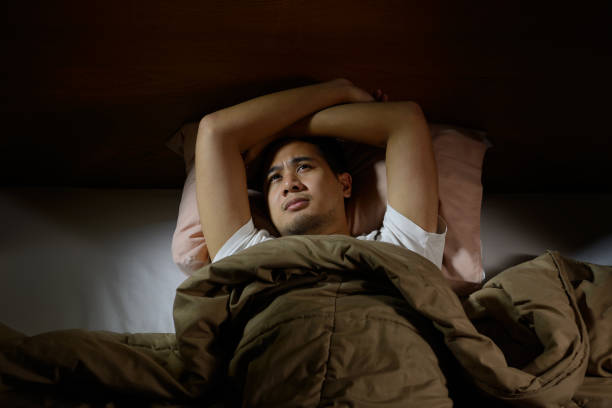 istock Depressed man suffering from insomnia lying in bed 820817722
