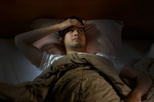 istock Depressed man suffering from insomnia lying in bed 820817782