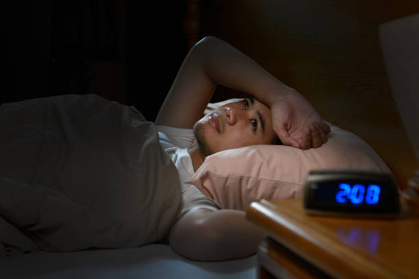 istock Depressed man suffering from insomnia lying in bed 820817800