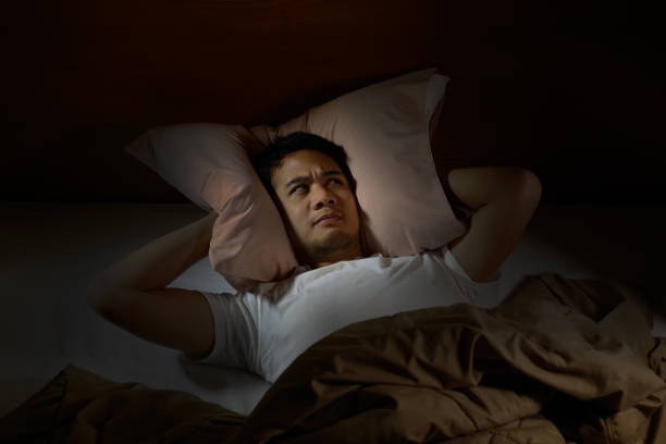istock Depressed man suffering from insomnia lying in bed 820817988