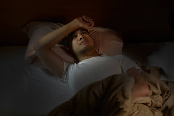 istock Depressed man suffering from insomnia lying in bed 820818014