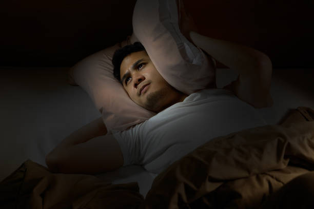 istock Depressed man suffering from insomnia lying in bed 820818410