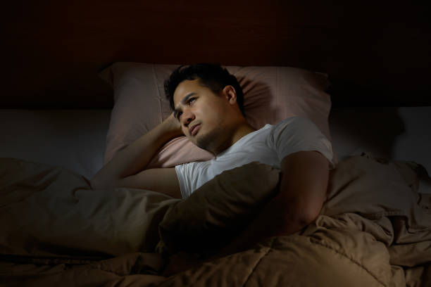 istock Depressed man suffering from insomnia lying in bed 820818422