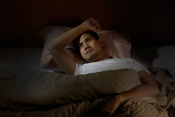 istock Depressed man suffering from insomnia lying in bed 820818442