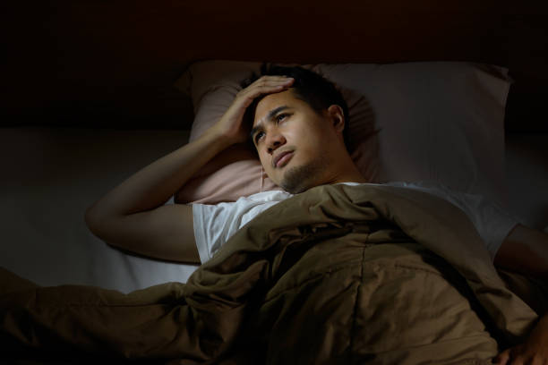 istock Depressed man suffering from insomnia lying in bed 820818448