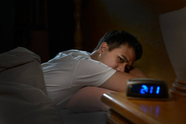 istock Depressed man suffering from insomnia lying in bed 820818488