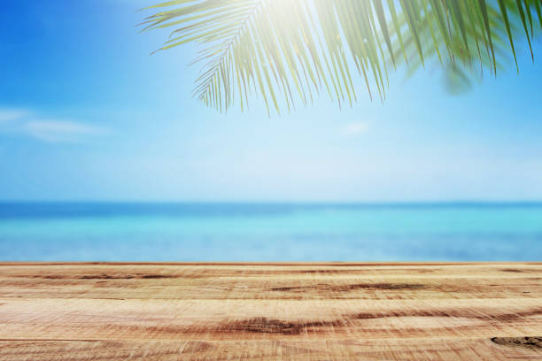 istock Beach background with palm tree and wooden table. 820818664