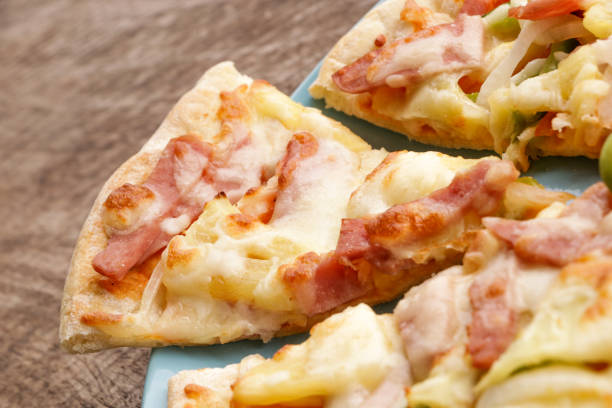istock Hot pizza slice on wooden table 820821548