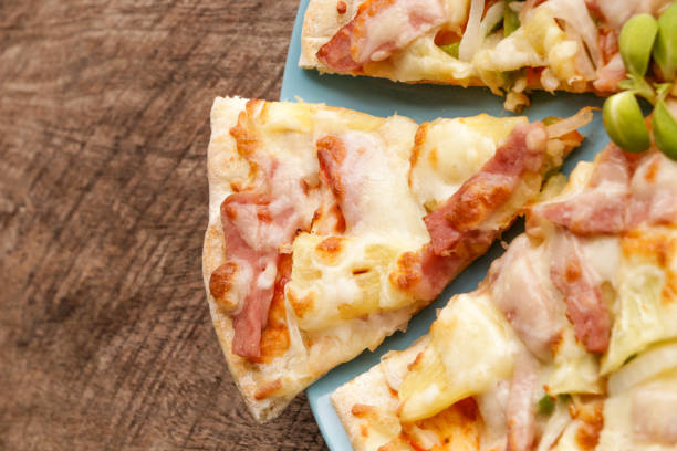 istock Hot pizza slice on wooden table 820821580