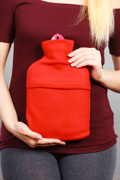 istock Woman holding warm red hot water bottle 820822928