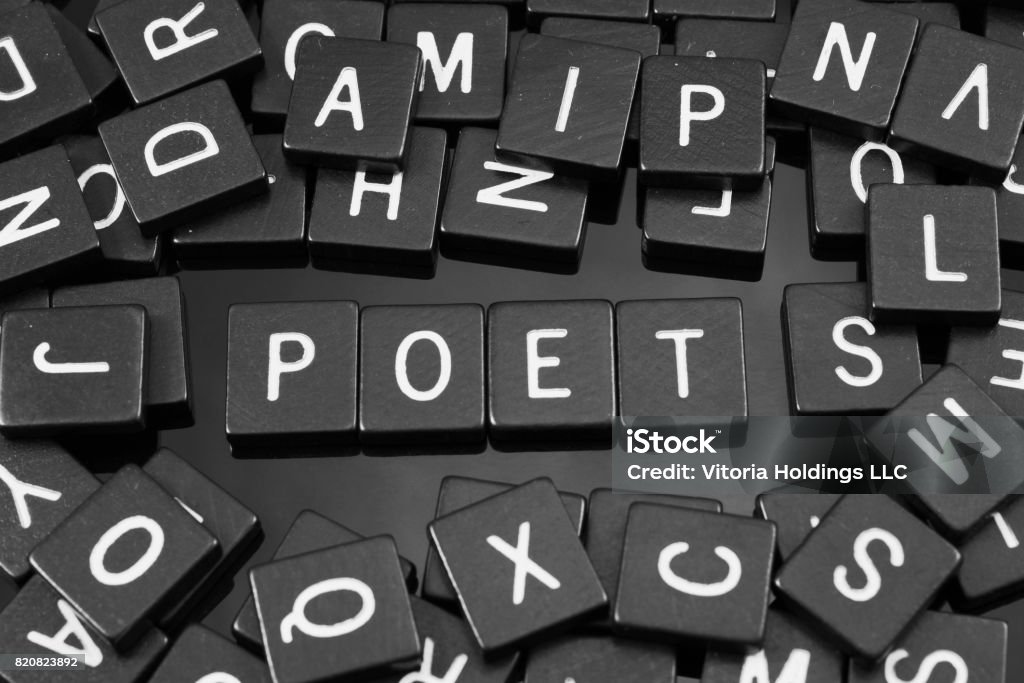 Black letter tiles spelling the word "poet" Black letter tiles spelling the word "poet" on a reflective background Abstract Stock Photo