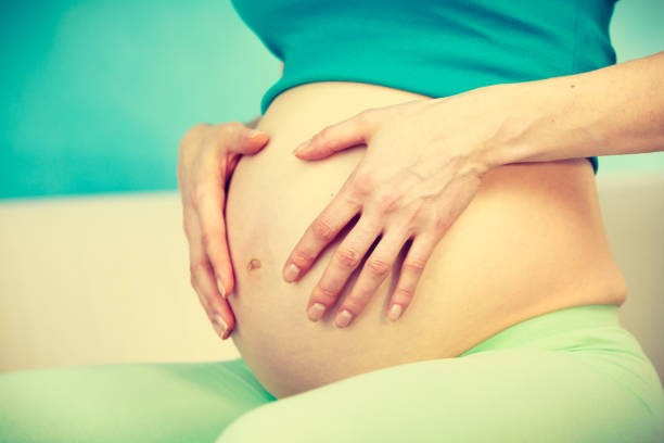 istock Pregnant woman caressing her belly 820829816