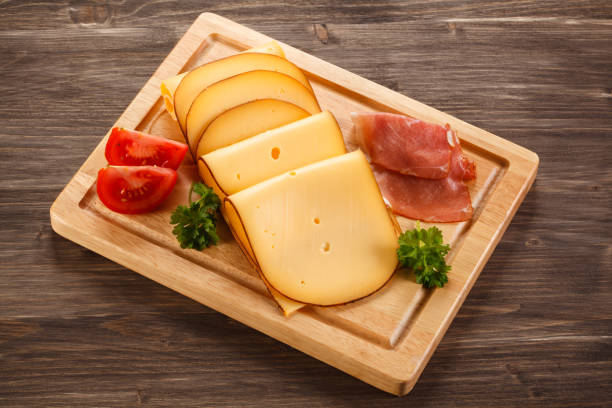 Cheese on cutting board Cheese on cutting board gouda cheese stock pictures, royalty-free photos & images