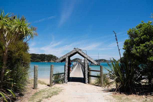 cais de ferry de turista tem arco decorado com arte maori na ilha de urupukapuka, baía das ilhas, nova zelândia, nova zelândia - new zealand culture indigenous culture bush maori - fotografias e filmes do acervo