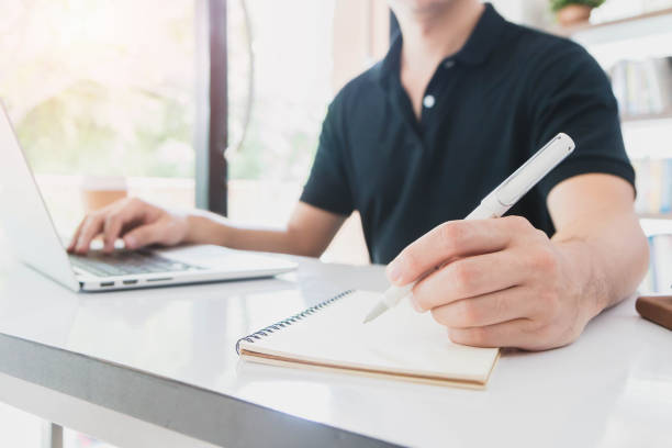 istock Businessman working and writing notebook on the table in office interior background. 820836094