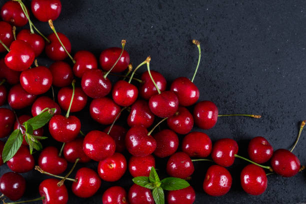 istock Sweet cherries  With mint leaves as a background 820837798