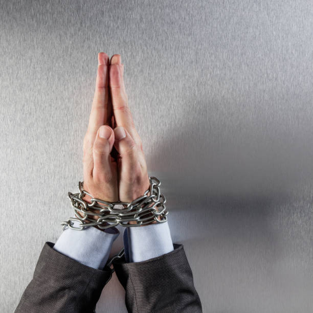istock praying businessman flat hands tied with chain begging for peace 820843940