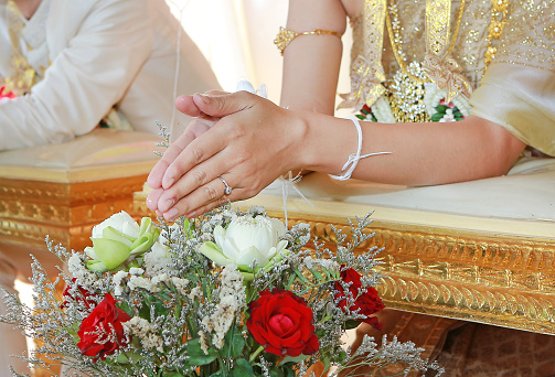 Hands pouring blessing water into bride's bands, Thai wedding.