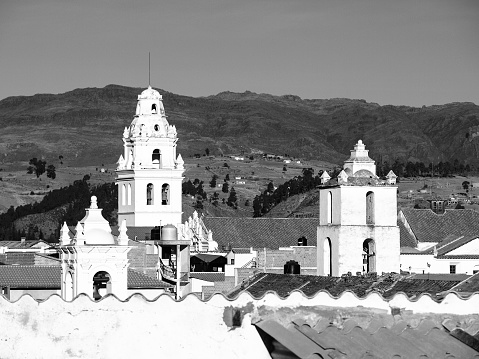 White colonial bell towers and orange rooftops in Sucre, Bolivia, South America. Black and white image.