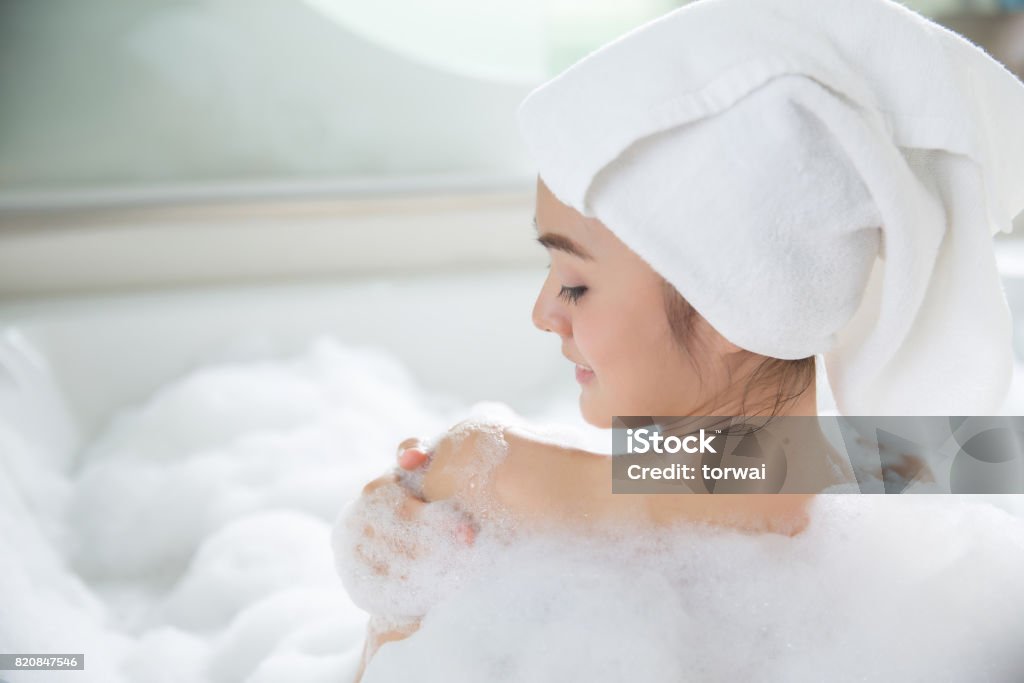 As mulheres asiáticas são chuveiro na banheira - Foto de stock de Mulheres royalty-free