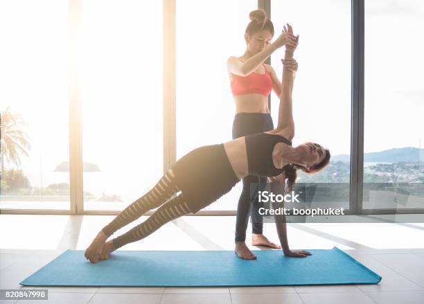 Yoga Teachers Or Yoga Trainer Are Teaching Side Plank Pose And Help To Adjust The Posture And Balance Of The Body To Older Womens Beginner Yoga Stock Photo - Download Image Now