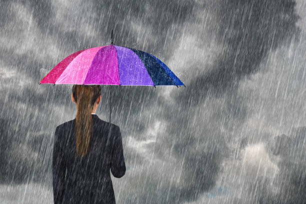 istock business woman holding multicolored umbrella under sky with falling rain 820851300