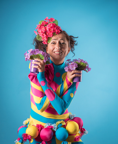 Beautiful young woman with  Flower pots  over colored background