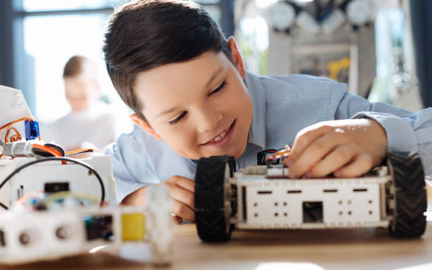 istock Cute boy touching a part in his robotic vehicle 820856186